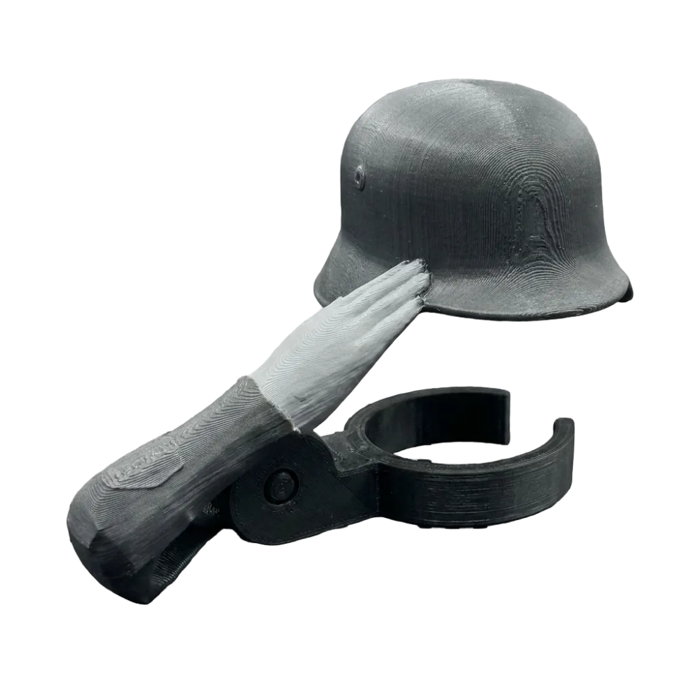 A miniature black helmet with a white hand saluting, mounted on a black plastic clip, shown against a black-and-white checkered transparency background.
